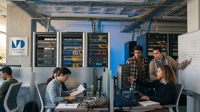 A student working at a server rack in a technology lab