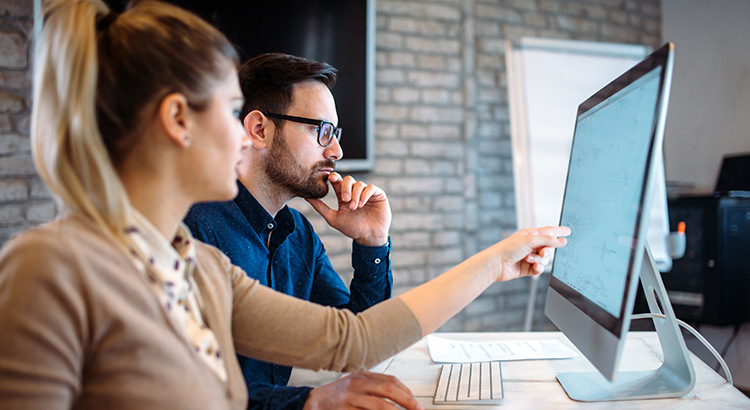 Two students sit at a desk analyzing information 