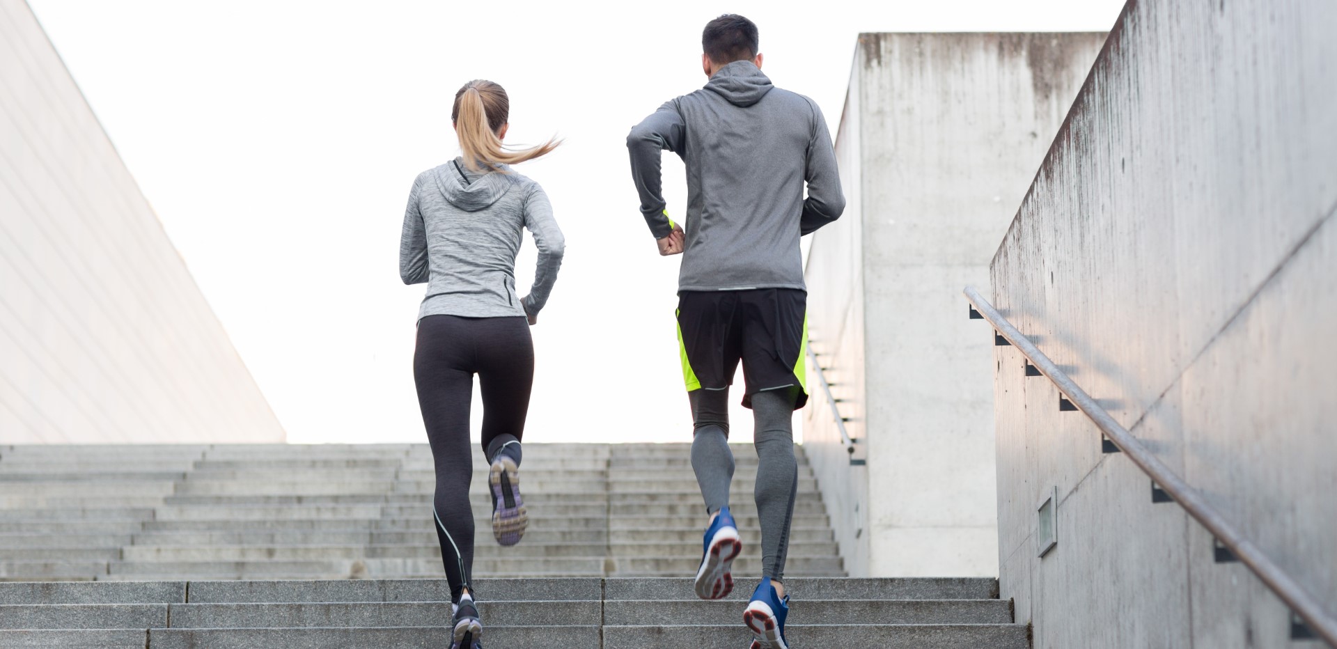 A man and a woman job up a flight of stairs