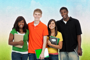 A group of students  standing together, smiling  and holding notebooks.
